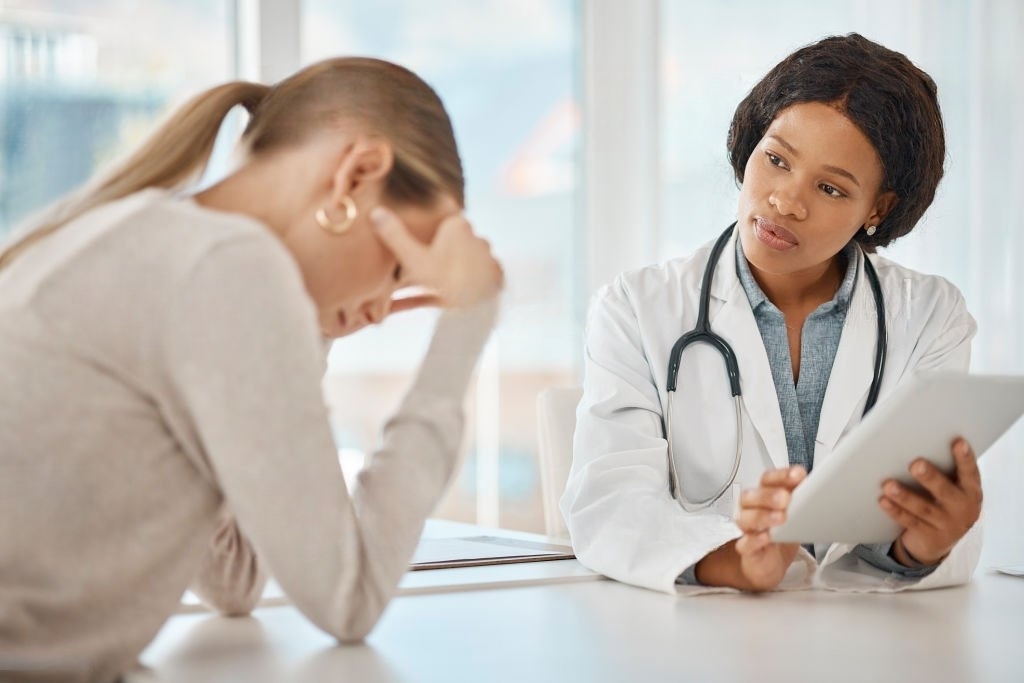 A female doctor conversing with a female patient