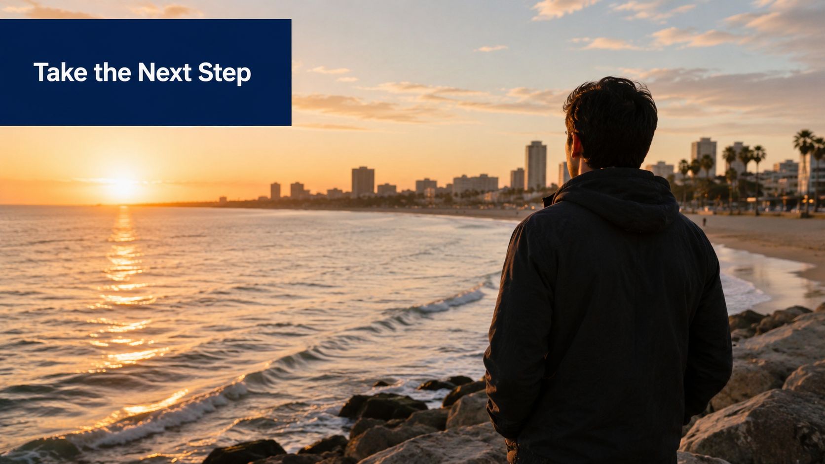 A young man looking at the sunset over the Long Beach coastline and city skyline.